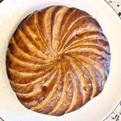 Złocista galette des rois, pieczona do perfekcji, czeka na odkrycie ukrytej w niej figurki.