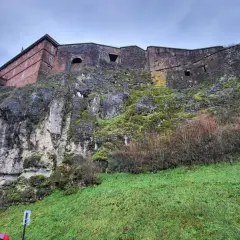 Potężny belfort wznosi się na skalistym zboczu porośniętym mchem.
