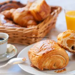 Idealne francuskie śniadanie: świeże croissanty, kawa i sok pomarańczowy.
