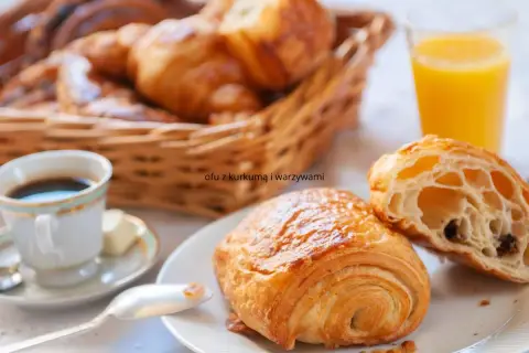 Idealne francuskie śniadanie: świeże croissanty, kawa i sok pomarańczowy.