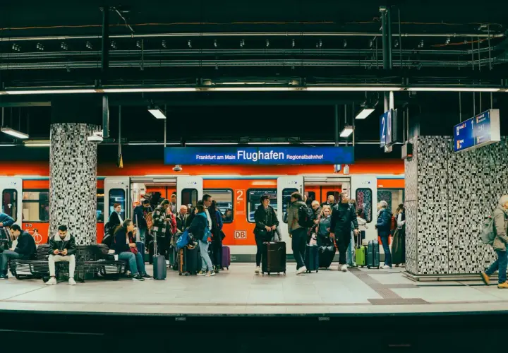 Ludzie z bagażami czekają na pociąg na stacji Frankfurt am Main Flughafen Regionalbahnhof.