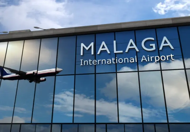 Samolot leci nad nowoczesnym budynkiem lotniska Malaga w Andaluzji.