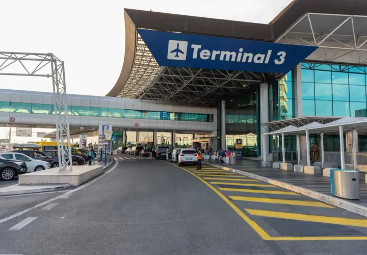 Terminal 3 lotniska Rzym Fiumicino. Samochody czekają przed wejściem, ludzie z bagażami.