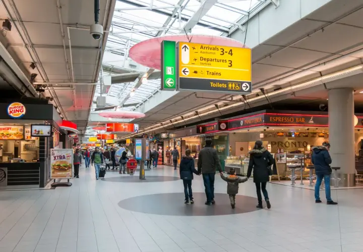 Lotnisko w Amsterdamie: rodzina idzie przez terminal, obok Burger Kinga i sklepów.