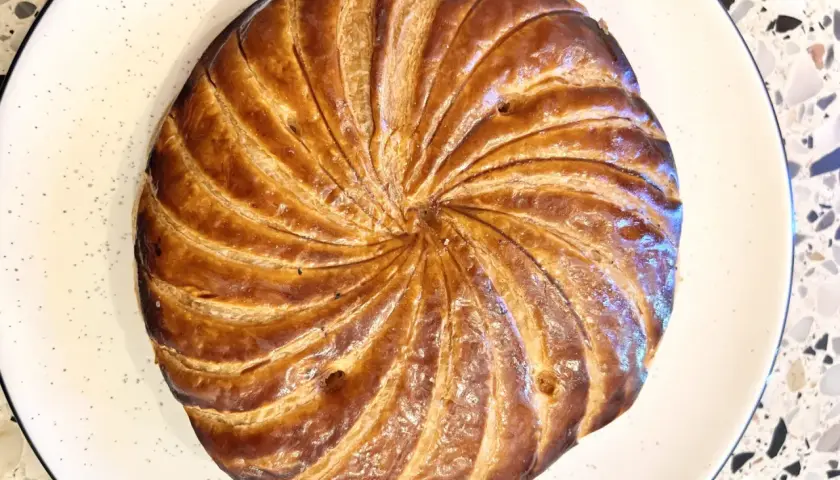 Złocista galette des rois, pieczona do perfekcji, czeka na odkrycie ukrytej w niej figurki.