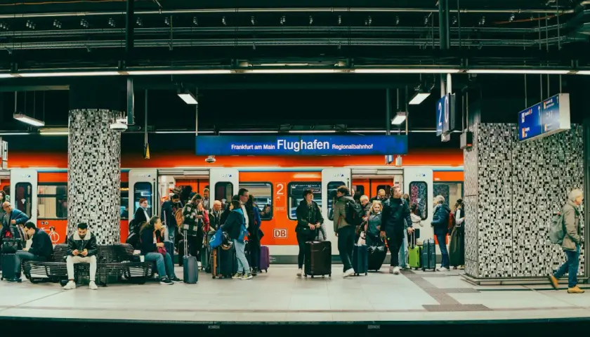 Ludzie z bagażami czekają na pociąg na stacji Frankfurt am Main Flughafen Regionalbahnhof.