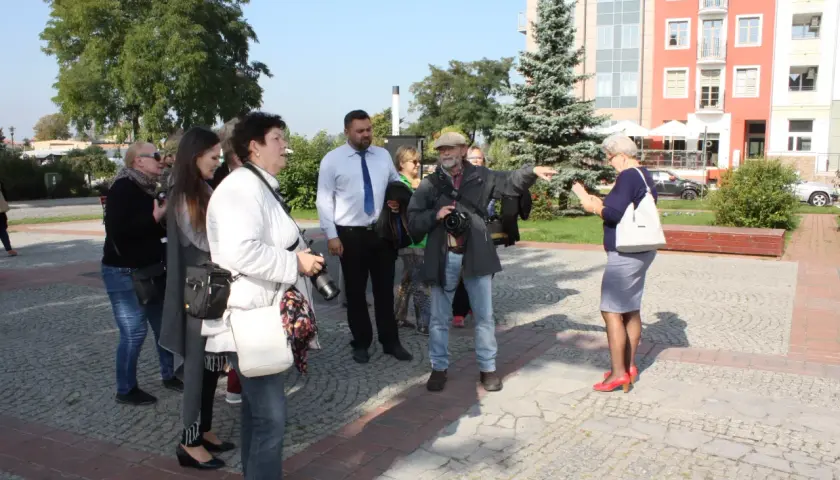 Grupa osób po francusku, przewodnik pokazuje drogę.