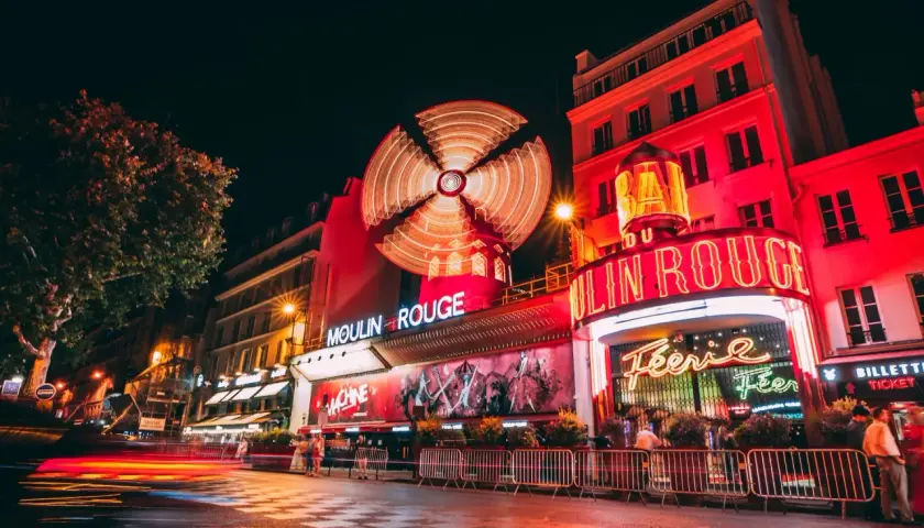 Nocny Paryż rozświetlony neonami. Słynny kabaret Moulin Rouge z wirującym wiatrakiem na dachu zaprasza na wieczór pełen wrażeń.